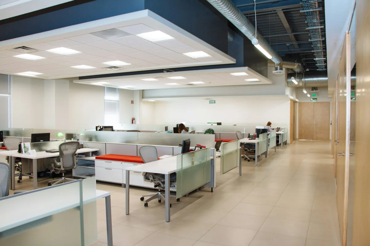 Empty small open-plan office with desks and frosted glass partitions